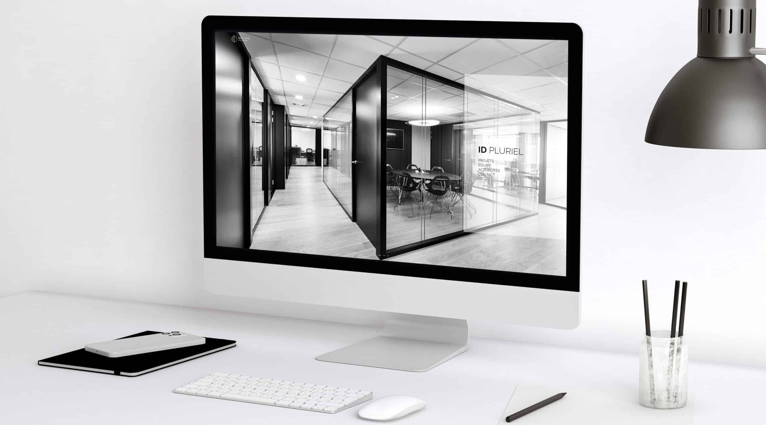 Site ID Pluriel Architectures affiché sur une tablette sur fond marbre